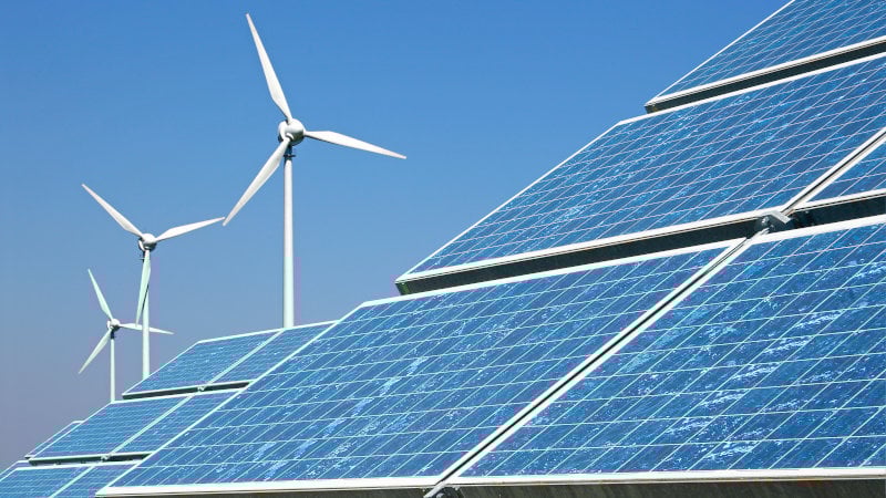 Windkraft- und Photovoltaik-Anlagen vor blauem Himmel