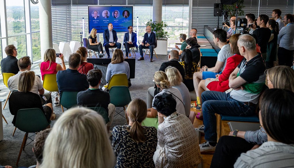 Podiumsdiskussion bei Wayra im O₂ Tower München mit Markus Haas, CEO von Telefónica Deutschland, CFO Markus Rolle und CTIO Mallik Rao vor großem Publikum.