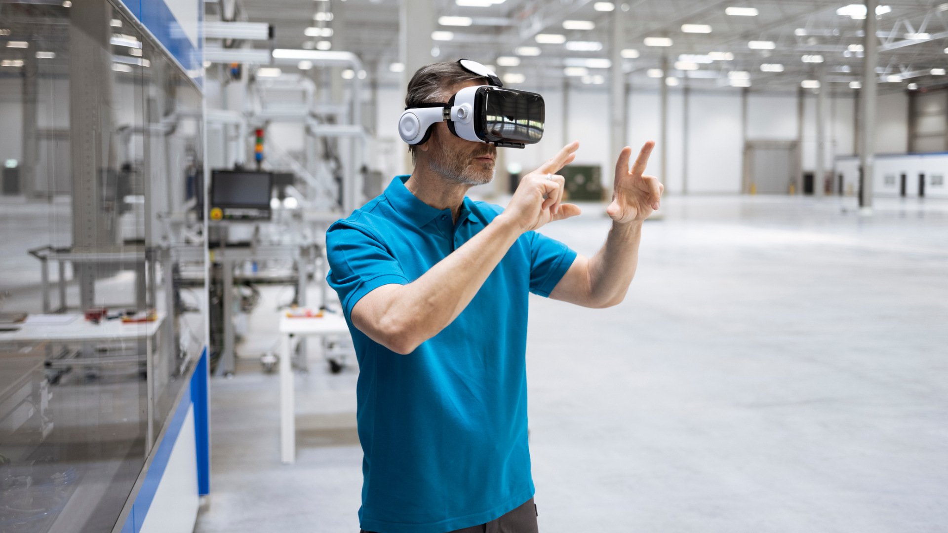 Ein Mann arbeitet mit VR-Brille in einer Fabrikhalle