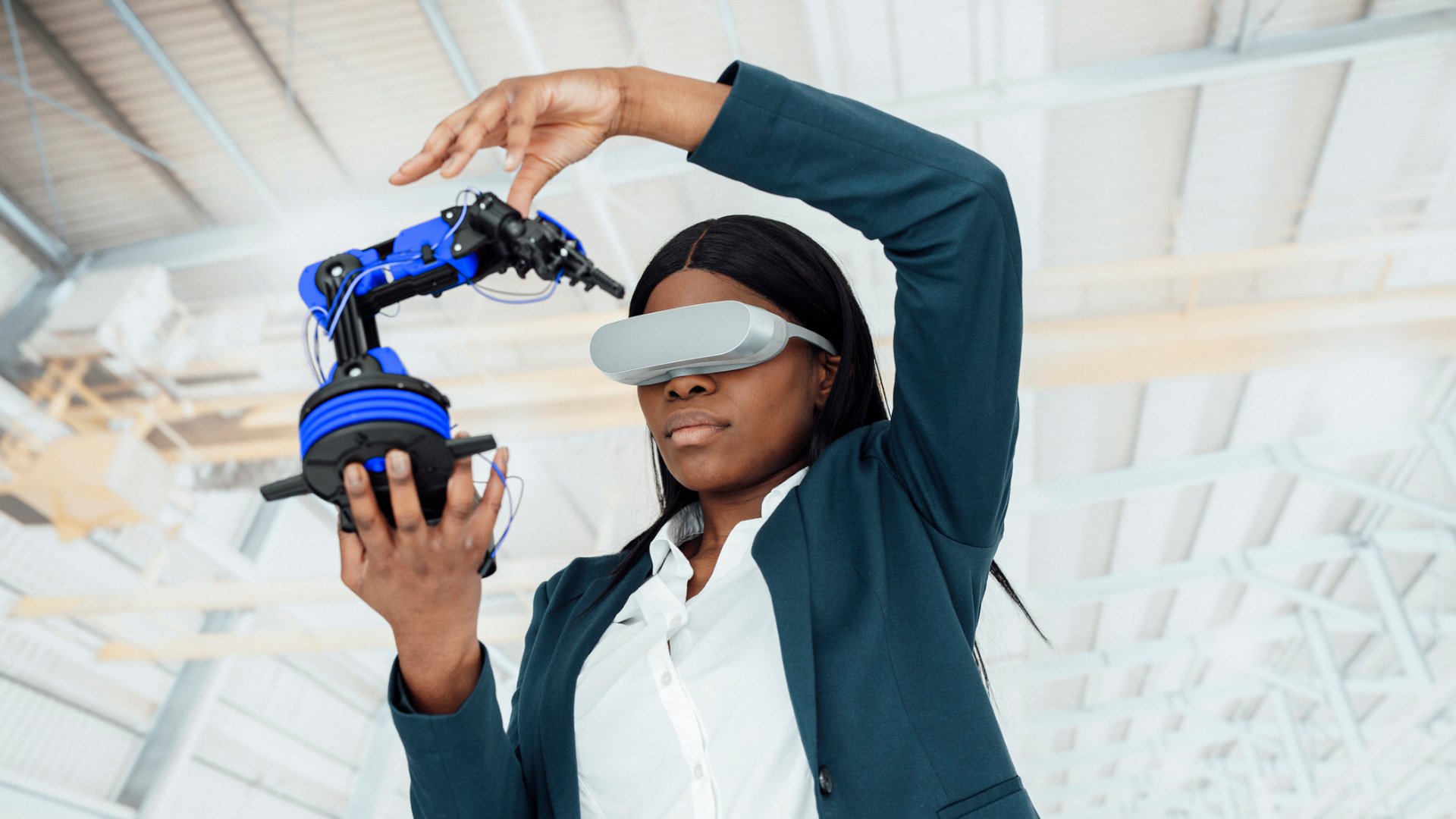 Eine Frau mit VR-Brille hält einen Roboter in der Hand 