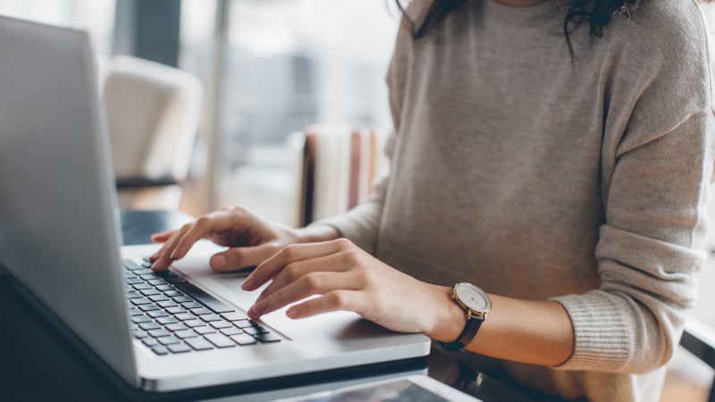 Eine Frau tippt auf einem Laptop