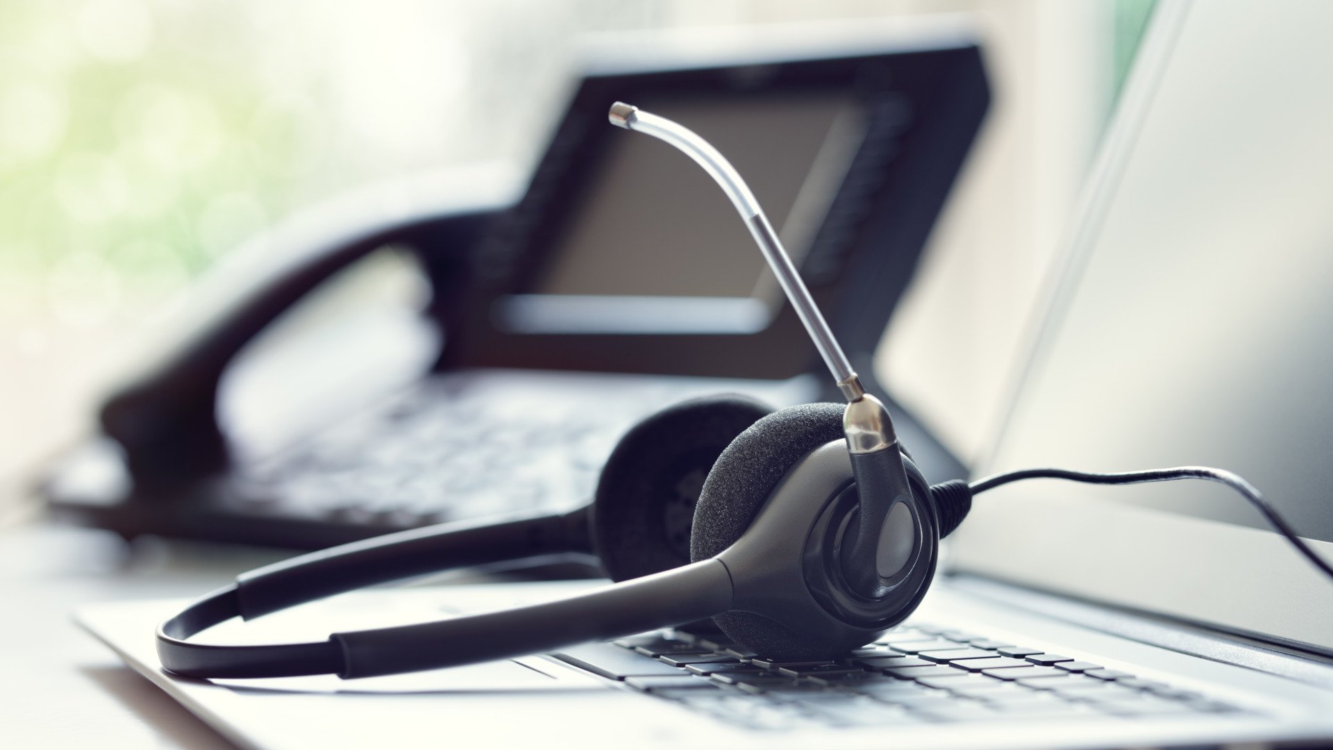 Ein Headset zur Telefonie liegt auf einer Laptop-Tastatur