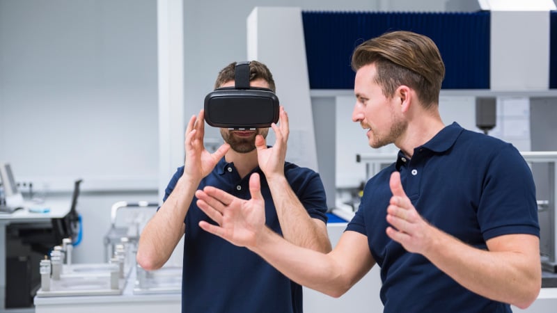 Zwei Mitarbeiter arbeiten mit einer VR-Brille