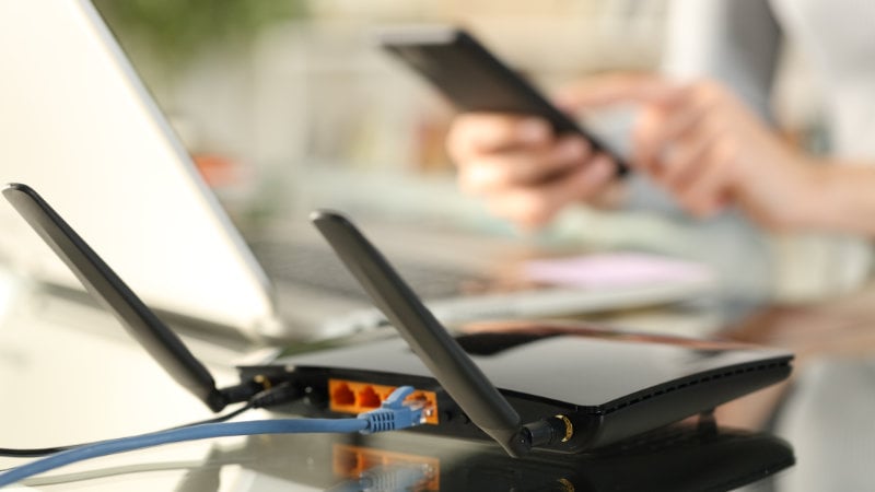 Ein WLAN-Router versorgt Laptop und Smartphone mit einem Signal