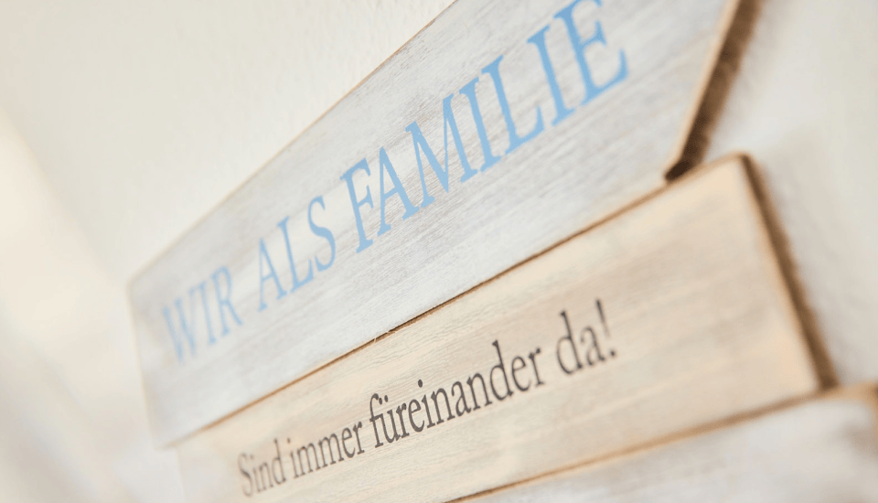 Zwei Holzschilder mit der Aufschrift "Wir als Familie" und "Sind immer füreinander da!"