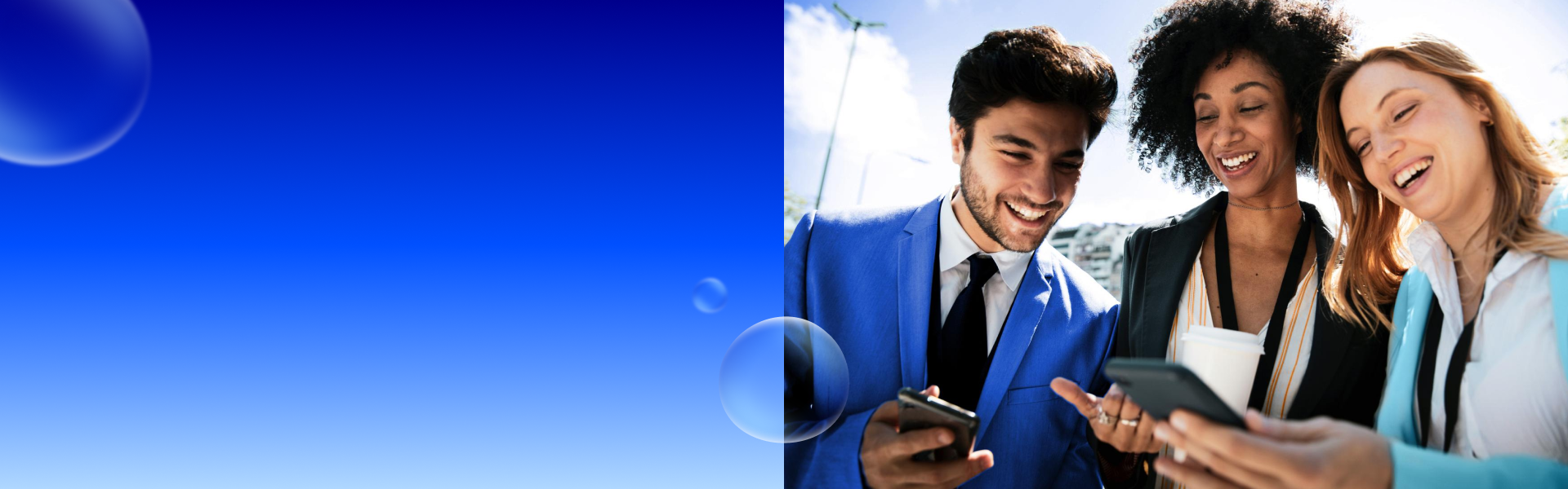 Zwei Frauen und ein Mann stehen lachend nebeneinander und schauen auf ihre Smartphones.