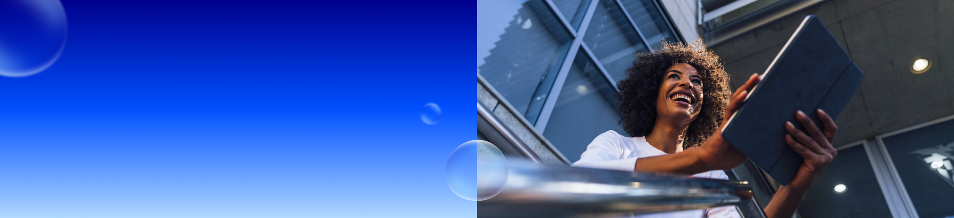 Abbildung: Eine Frau mit einem Tablet in der Hand schaut lachend in die Ferne