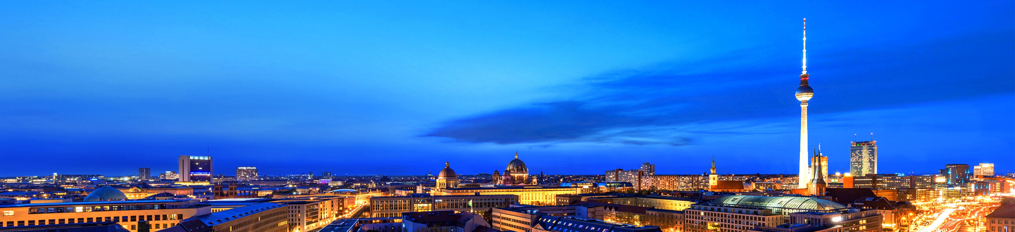 Abendliche Skyline von Berlin mit beleuchtetem Fernsehturm am Alexanderplatz