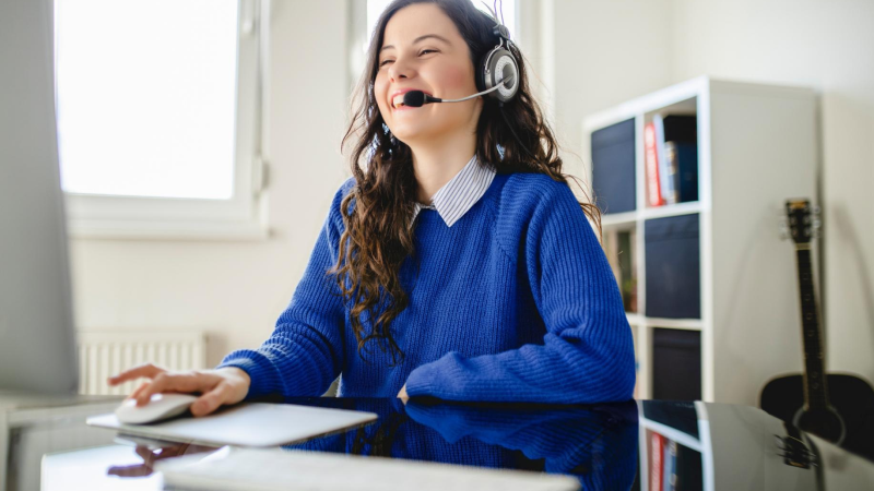 Abbildung: Frau mit Headset arbeitet am Computer