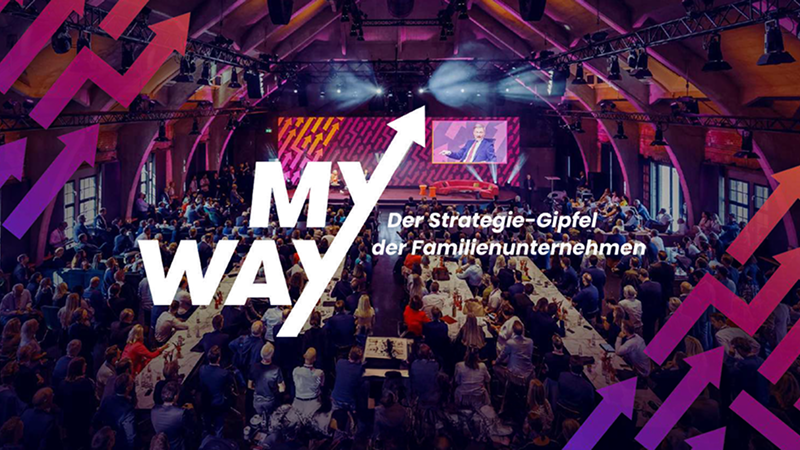 Abbildung: Bühne mit großem Publikum, Schriftzug „MY WAY – Der Strategie-Gipfel der Familienunternehmen“. Darunter „Venue Partner Westhafen Event & Convention Center“ und Datum „24. & 25. September 2025, Berlin“
